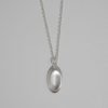 Y2K-inspired silver loop necklace, featuring a geometric 'pill-button' pendant with a futuristic, ergonomic design and high-shine finish.