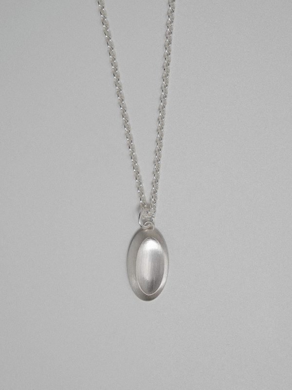 Y2K-inspired silver loop necklace, featuring a geometric 'pill-button' pendant with a futuristic, ergonomic design and high-shine finish.