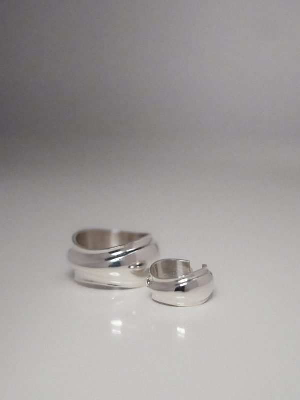 A thick, polished metal band and ear cuff with a convex, 'puffy' swell. The design features a smooth, pressurized organic curve resembling 2000s bubble-shell hardware.