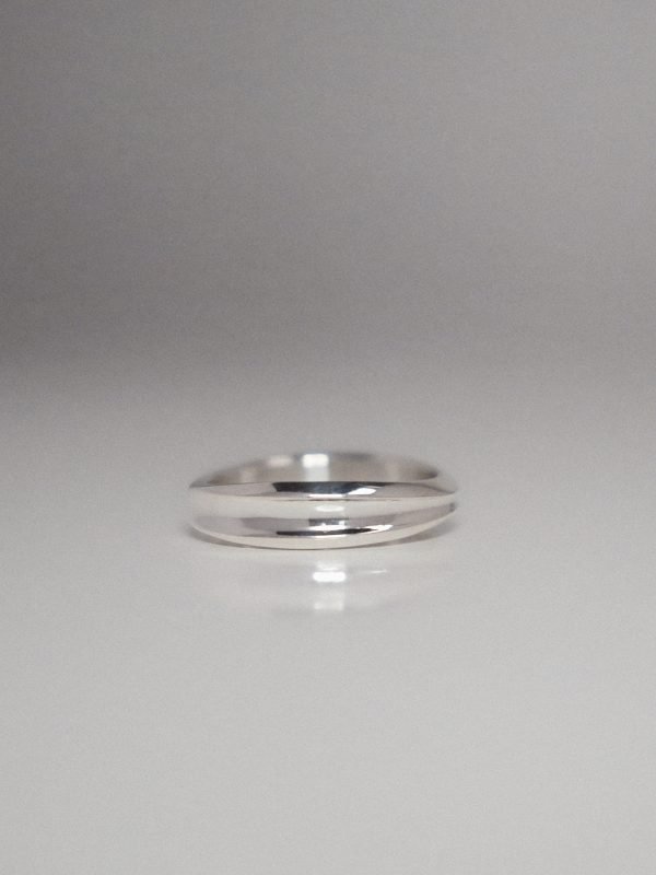 A slim, polished silver band featuring a central recessed trough and dual-sloped lateral walls, reflecting a minimalist 2000s tech-hardware aesthetic.